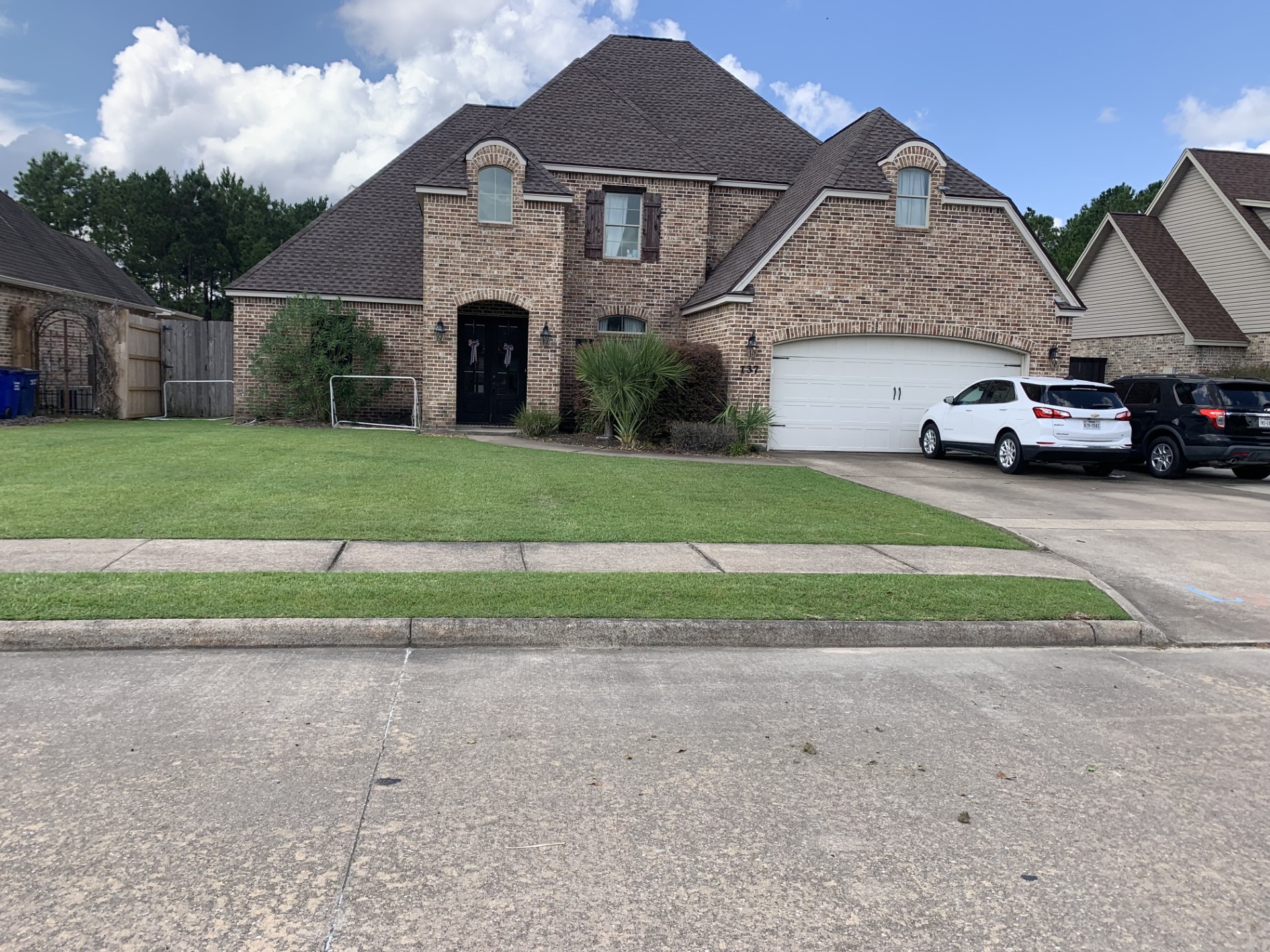 Maintained residential lawn in front of a brick home